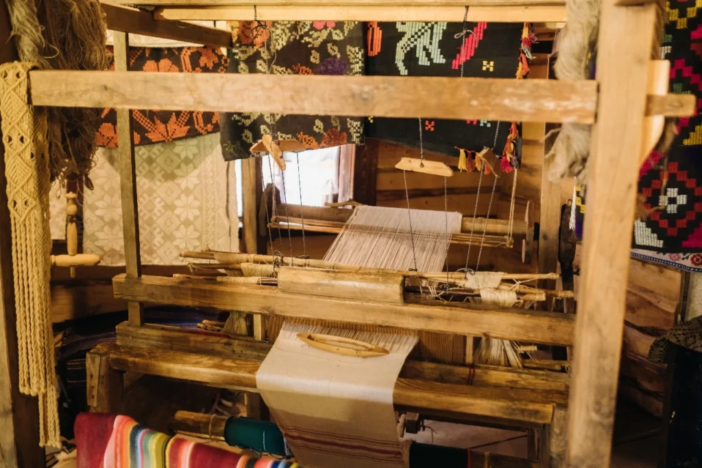 Traditional wooden loom used for weaving Pashmina and Cashmere fabrics, showcasing artisanal craftsmanship and fine wool textures.